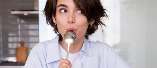 金属スプーンではちみつを食べている人